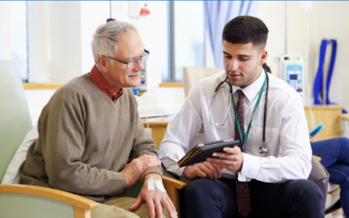 An older man in a care setting with a doctor